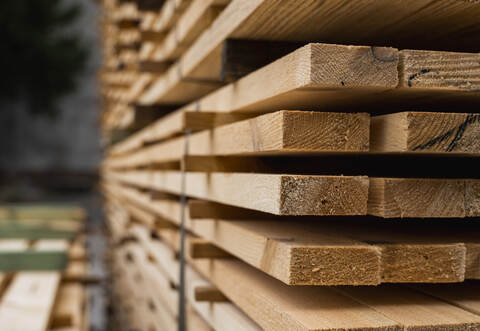 Piles of wooden boards in the sawmill, planking. Warehouse for sawing boards on a sawmill outdoors. Wood timber stack of wooden 