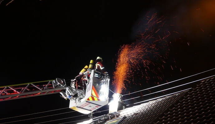 Teilweise schossen Flammen aus dem Kamin, während die Feuerwehr den Brand mithilfe einer Drehleiter bekämpfte. Teilweise schossen Flammen aus dem Kamin, während die Feuerwehr den Brand mithilfe einer Drehleiter bekämpfte.