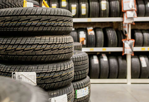 Car tires and wheels at warehouse in tire store.