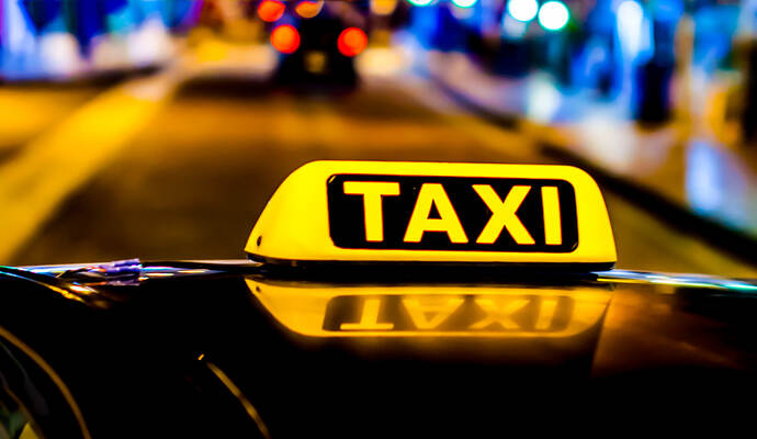Die Polizei sucht den Fahrer eines schwarzen Taxishuttles. Night photo of a taxi car. Taxi sign on the car roof glowing in the dark