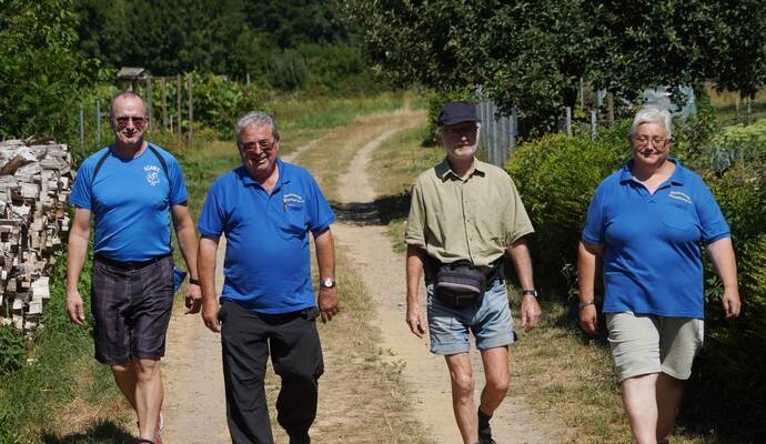 Willkommen im Ziel: Bill Heisser (links), Günter (Zweiter von links) und Martina Leonhard (rechts) begleiten einen Wanderer auf den letzten Metern vor dem Erreichen der Kämpfelbachhalle in Bilfingen.