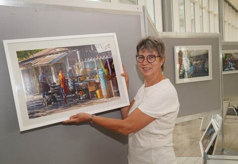 Beeindruckende Bilder: Angela Gewiese von der Stabsstelle Klimaschutz und Kreise ntwicklung hängt die Fotos für die Ausstellung im Foyer des Landratsamts in Pforzheim auf. Dieses hier zeigt eine mit Holzkohle befeuerte Straßenküche.