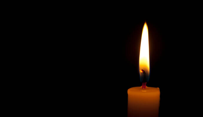 Horizontal photo of lighted candle isolated on black background