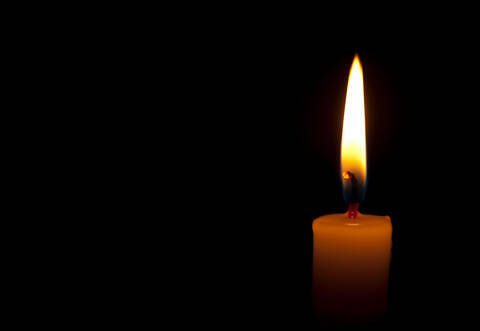 Horizontal photo of lighted candle isolated on black background