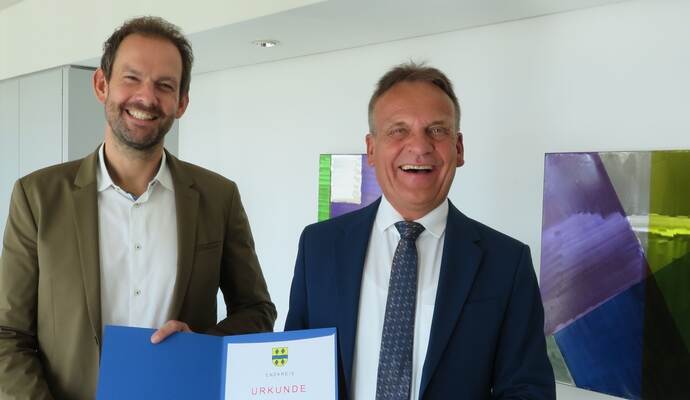 Udo Kleiner (rechts) erhielt aus den Händen von Landrat Bastian Rosenau seine offiziellen "Entlassungspapiere".