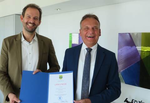 Udo Kleiner (rechts) erhielt aus den Händen von Landrat Bastian Rosenau seine offiziellen "Entlassungspapiere".