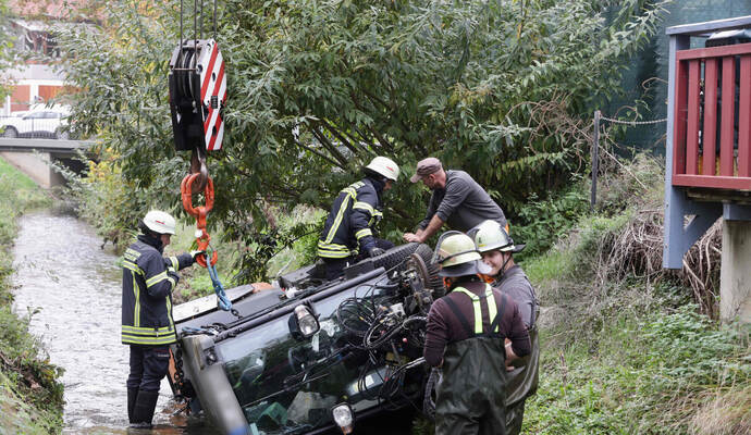 Die Kehrmaschine wird mit einem Kran der Feuerwehr aus dem Kämpfelbach geborgen.