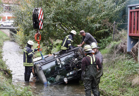 Die Kehrmaschine wird mit einem Kran der Feuerwehr aus dem Kämpfelbach geborgen.