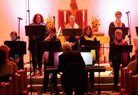 Stimmungsvoll beleuchtet: Vor dem Altarraum haben die Sängerinnen des Chors „Con Musica“ in der Feldrennacher Kirche Aufstellung genommen.