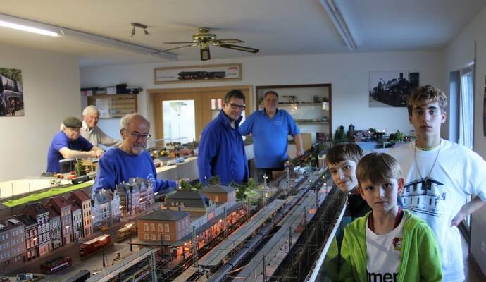 Während Dennis Haas (von rechts) den jungen Besuchern Fabian und Sebastian Erndwein an der Modellbahnstrecke Rede und Auskunft stand, kümmerten sich Roland Fränkle, Stefan Eisen und Helmut Augenstein um den reibungslosen Fahrtbetrieb. Foto: Zachmann