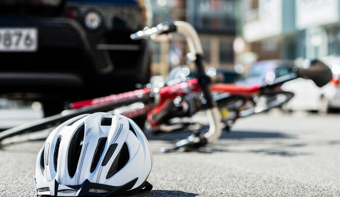 Close-up of a bicycling helmet on the asphalt  next to a bicycle