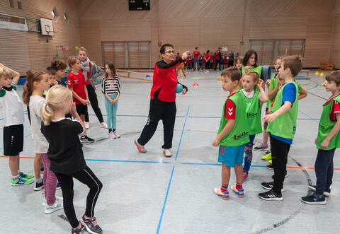 Trainerin Manuela Schrenk erklärt den Kindern der Wiernsheimer Heckengäuschule die Handballregeln.
