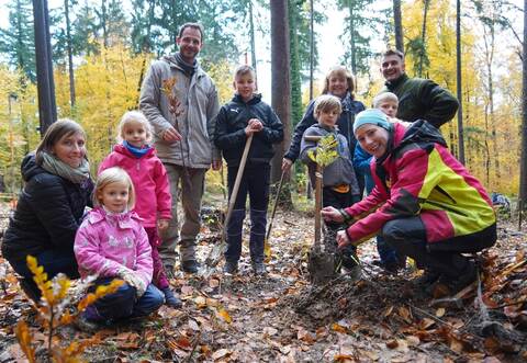 Alle helfen mit: Bürgermeister Thomas Maag (Mitte, stehend) und Försterin Sarah Zwerenz (rechts) freuen sich über die vielen Kinder und Eltern bei der Baumpflanzaktion.
