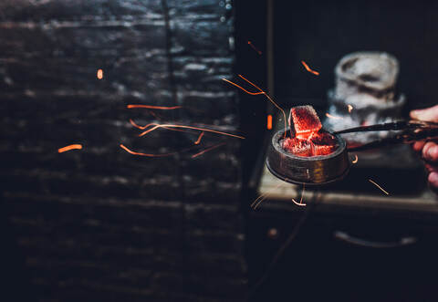 Shisha hookah with red hot coals. Sparks from breathe. Modern hookah with coconut charcoal for relax and shisha smoke. Hookah an