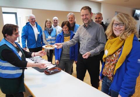 Gulasch für den Rathauschef: Auch Bürgermeister Luca Wilhelm Prayon (Dritter von rechts) kommt zur Eröffnung der Vesperkirche – sehr zur Freude der Ehrenamtlichen um Karl-Heinz Stengel (Zweiter von links).