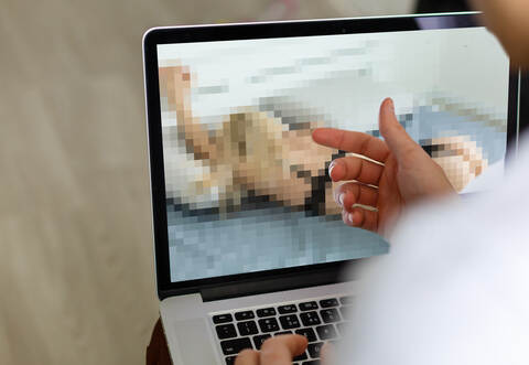 closeup of a young caucasian man watching a nude woman in his computer