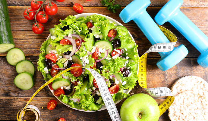 Gesunde Ernährung und sportliche Bewegung - die PZ/AOK-Frühjahrskur verbindet beides auf eine praxisnahe, gesunde Art, die es möglich macht, die Kur auch im Alltag überall zu integrieren. diet food concept- salad with dumbbell and meter