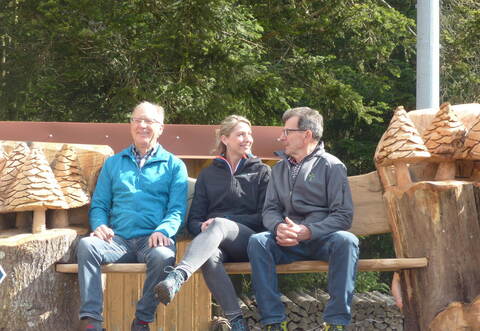 Ein Überraschungspräsent hatte Stefanie Dickgießer mit der kunstvoll geschnitzten Bank im Gepäck. Die Ehrenamtlichen Georg Kappler (links) und Willi Kübler konnten schon mal Probe sitzen.