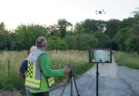 Pilot Thomas Kälber steuert die Drohne über dem Gewann Schneit in Kieselbronn. Auf einem Bildschirm wird die Aufnahme verfolgt.