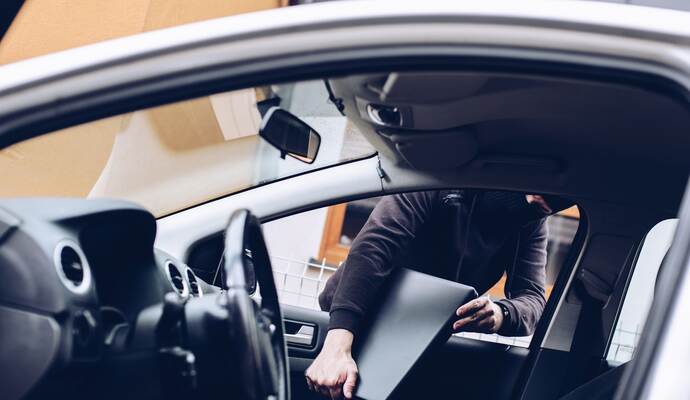 In Lomersheim wurde ein Laptop aus einem Auto gestohlen. Masked thief in a balaclava stealing laptop computer
