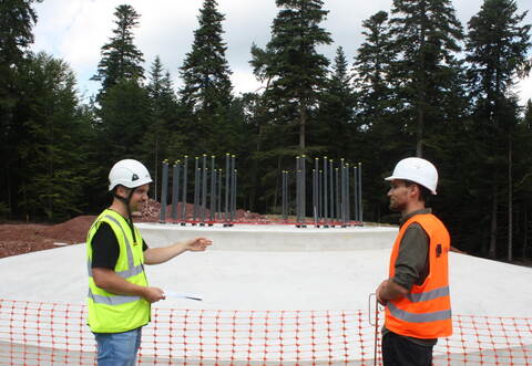 Bauleiter Björn Brabänder (links) und Projektleiter Thomas Reinhold freuen sich über das erste fertige Windrad-Fundament – das der Windenergieanlage 2 – auf der Langenbrander Höhe.