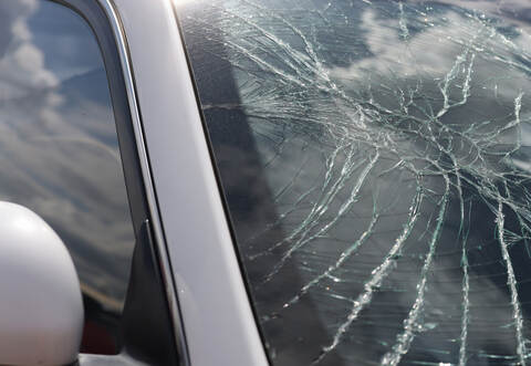 Closeup of cracks on broken car windshield