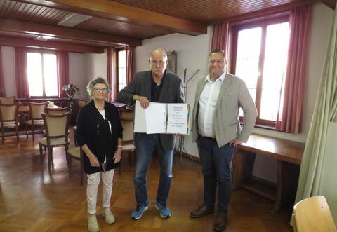 Hanne Rau und Roland Schwabenland übergeben den Einwohnerantrag mit 797 Unterschriften an Bürgermeister Marco Gauger (rechts).