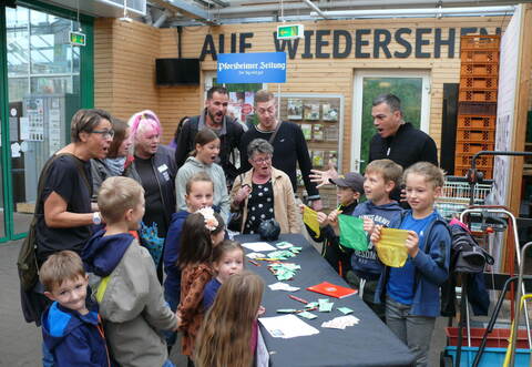Mit großer Begeisterung zeigen Kinder vom „MagicClub Neulingen“ am Ausgang im Gartencenter Streb in Pforzheim Kundinnen und Kunden die von Magier Marco Miele (hinten rechts) gelernten Zaubertricks den ebenfalls begeisterten Kindern und Erwachsenen.