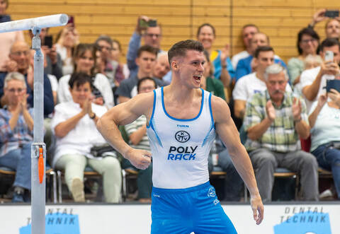 Lukas Dauser feiert seine erfolgreiche Kür am Barren.