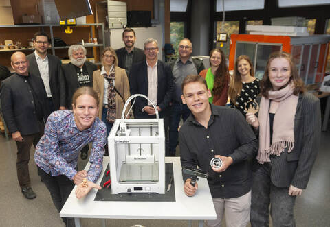 Benno Schreiber, Tim Neuberger und Mia Pannwitz (vorne von links) von der Schülerfirma weihen mit Vertretenden der Schule, der Stadt und des Kooperationspartners den NwT-Raum ein.