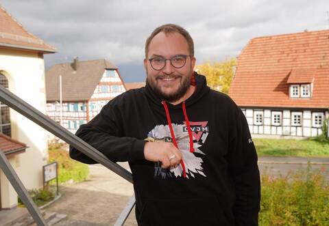 Diakon Raphael Beil steht auf den Stufen des Hauses, in dem er in Dürrn zusammen mit seiner Familie lebt. Es liegt direkt neben der Kirche, in der er Jugendliche eine Woche hat wohnen lassen. Bald zieht die Familie aus und verlässt die Region.