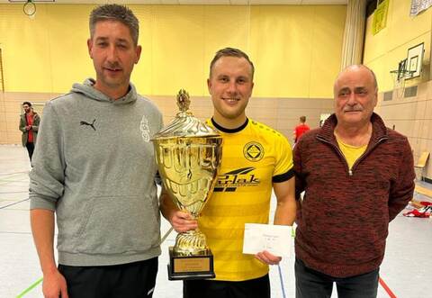 Den Wanderpokal überreichen Calmbachs Vorsitzender Michael Herder (links) und Bernd Rommel an GU-Kapitän David Kaul.