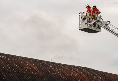 Mit der Drehleiter versuchen die Feuerwehrleute das Feuer zu löschen.