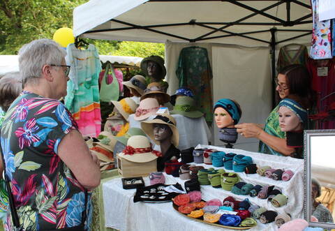 Ein schicker Hut für die Dame? Händler bieten auf einem Markt ihre Waren an.