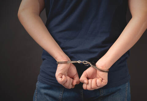 Arrested man with handcuffed hands