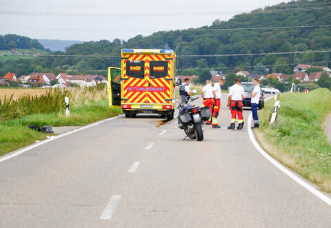Rettungskräfte stehen auf der Landstraße, die während der Rettungsmaßnahme voll gesperrt ist.