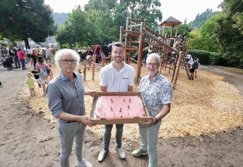 Mit einem Kuchen in Bolzplatzform feiern Architekt Volker Boden , Bürgermeister Fabian Bader und Bauunternehmer Max Hohenschläger (von links) die Eröffnung.