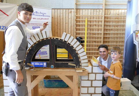 Früh übt sich: Rico Hofmann (von links) und Tim Konanz erklären dem Erstklässler Jonas Gindele das Maurerhandwerk.