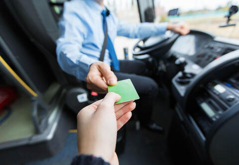 bus driver taking ticket or card from passenger